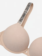 Close-up of a beige wireless bra cup and shoulder strap with a rhinestone-embellished band reading 'EVERYBODY'S SHAPED' on a light gray background.