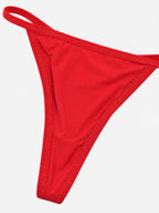 A bright red thong-style bikini bottom with textured trim along the edges, shown against a plain light gray background.