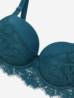 A close-up of a teal blue lace underwire bra cup and band, shown against a plain light gray background.
